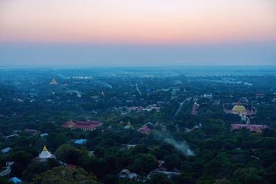 High angle view of city buildings against sky during sunset