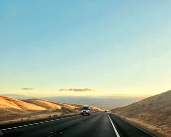 Car on road against sky during sunset