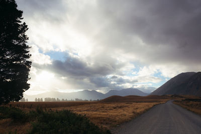 Road leading towards mountains against sky