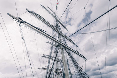 Low angle view of sailboat against cloudy sky