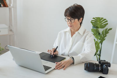 Doctor using laptop while sitting on table