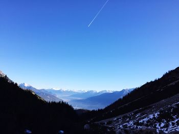Scenic view of silhouette mountains against blue sky