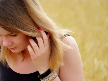 Close-up of young woman with hand in hair