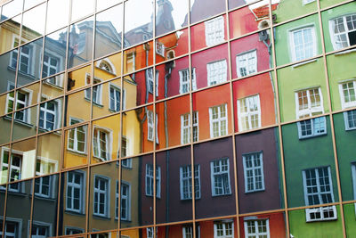 Reflection of multi colored buildings on glass building