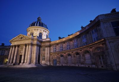 Low angle view of historical building against clear blue sky