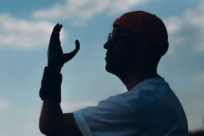 Close-up portrait of silhouette man with eyeglasses against sky during sunset