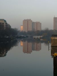 Reflection of buildings in lake against sky