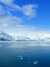 Scenic view of snow covered mountains against blue sky