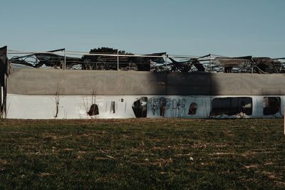 Factory on field against clear sky