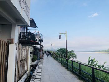 Footpath by sea against sky