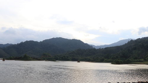 Scenic view of sea and mountains against sky