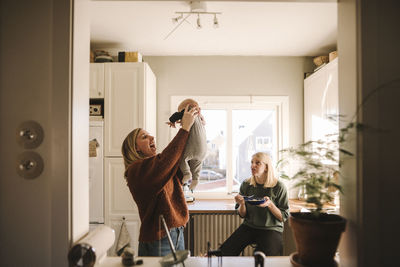 Mothers playing with newborn baby at home