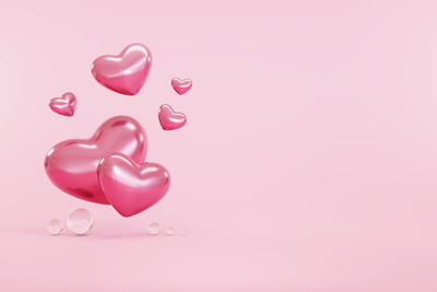 Close-up of heart shaped balloons against gray background