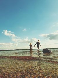 People at beach against sky