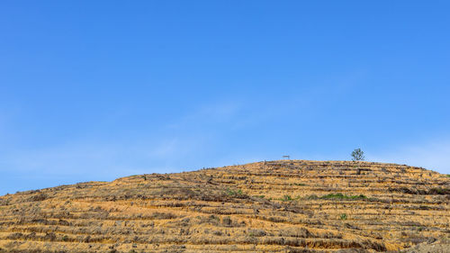 Low angle view of mountain against blue sky