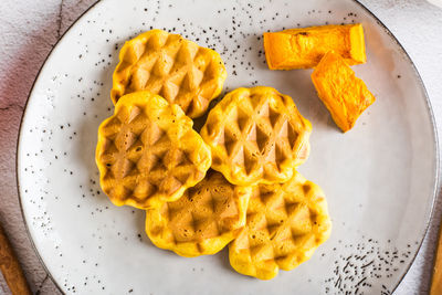 Pumpkin waffles on a plate on the table. homemade baking. top view. closeup