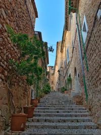 Low angle view of narrow alley amidst buildings against sky