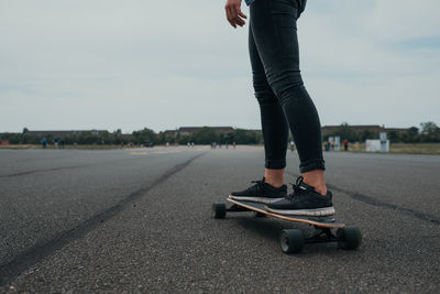 Low section of man skateboarding on road