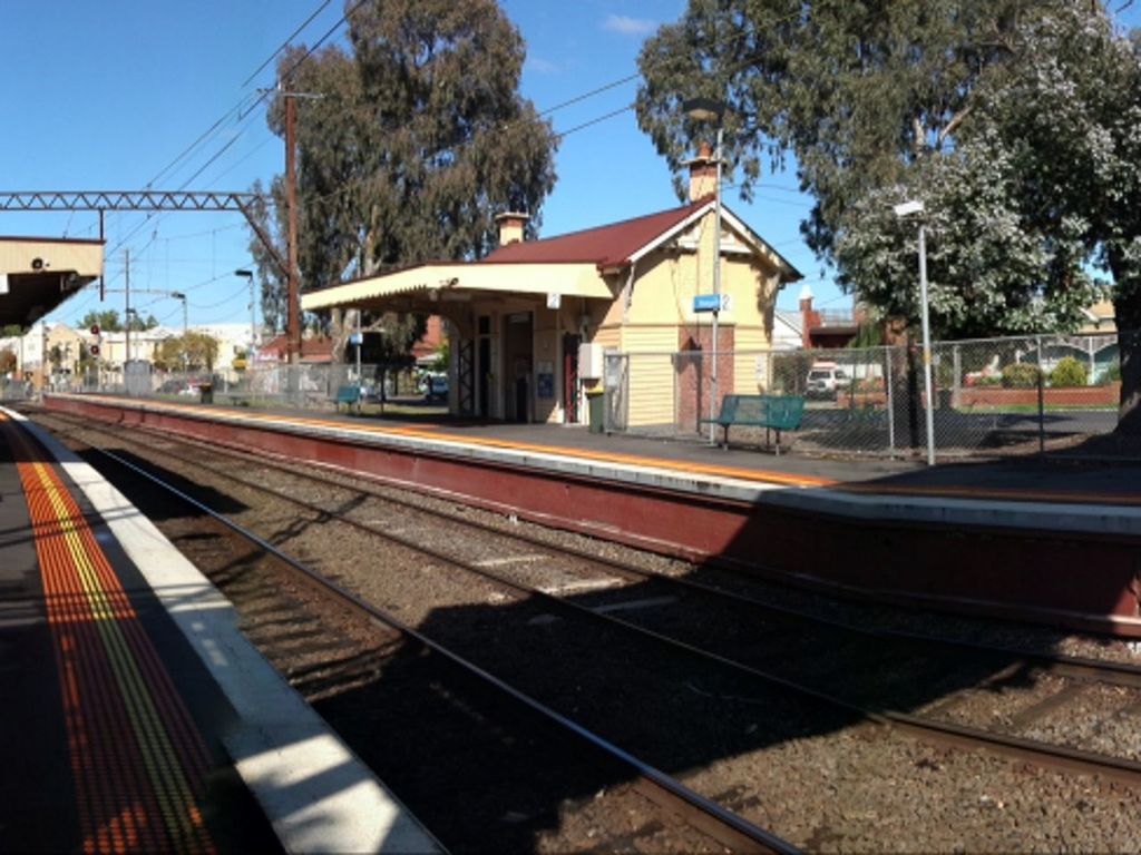 railroad track, transportation, public transportation, railroad station platform, rail transportation, railroad station, building exterior, built structure, architecture, mode of transport, city, train - vehicle, travel, train, public transport, clear sky, sky, tree, passenger train, road