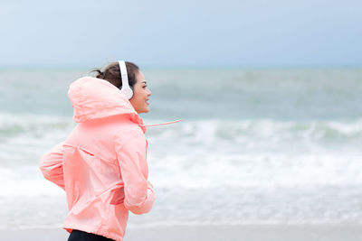 Woman standing on beach against sea