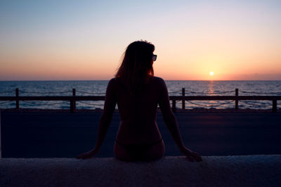 A young girl watching the sunset by the sea. holiday concept