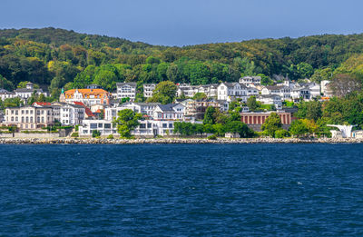 Scenic view of sea by buildings against sky