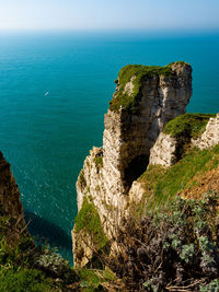 High angle view of rock formations by sea against sky