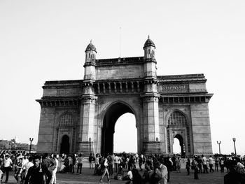 Tourists at gateway to india against clear sky