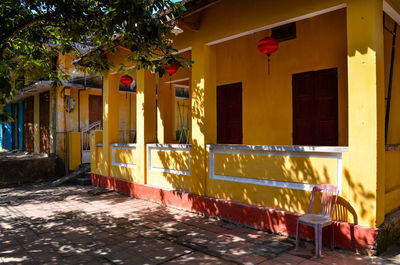 Empty chairs and tables against buildings in city