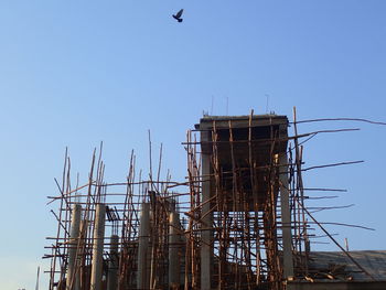 Low angle view of crane against clear sky