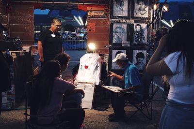 People at illuminated market stall