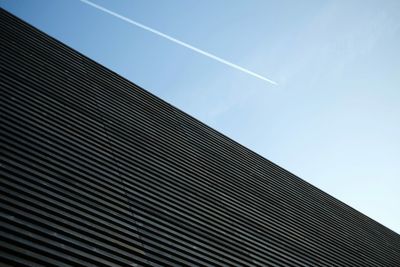 Low angle view of modern building against blue sky