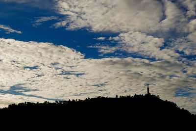 Low angle view of silhouette trees against sky