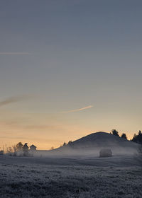 Scenic view of silhouette field against sky during sunset