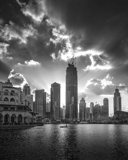 Buildings in city against cloudy sky