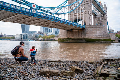 Father and son by thames river in city