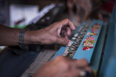 Midsection of man playing old musical instrument