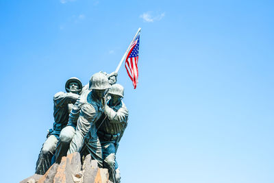 Low angle view of statue against blue sky