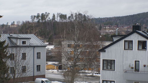 Houses and buildings against sky during winter