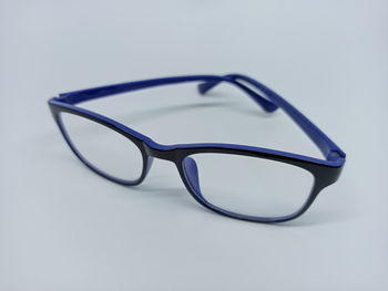 Close-up of eyeglasses on table against white background