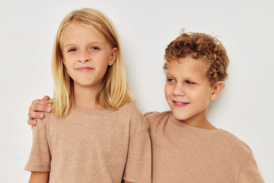 Portrait of smiling sibling against white background