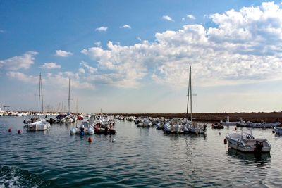 Boats moored at lake against sky