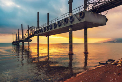 Pier over sea against sky during sunset