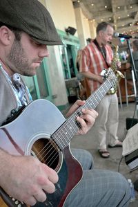 Midsection of man playing guitar