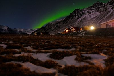 Surface level of snowy field against sky at night