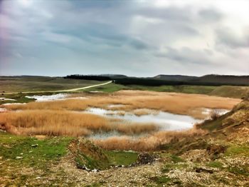Scenic view of landscape against cloudy sky