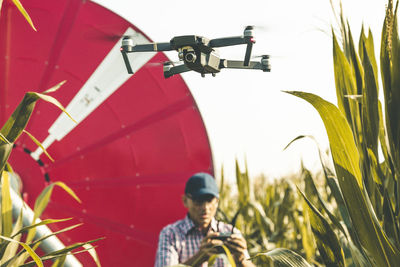 Man flying drone against clear sky in farm