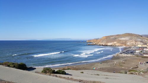 Scenic view of beach against clear blue sky