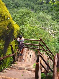 People on footbridge against trees