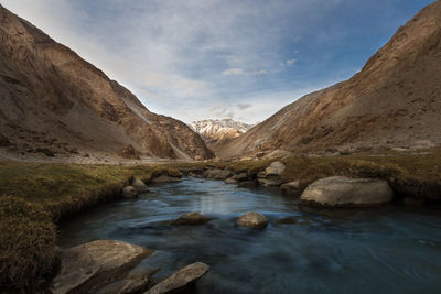 Scenic view of river amidst mountains against sky